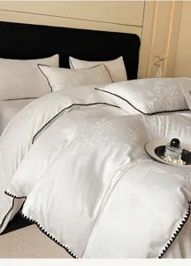 Vue détaillée d'une parure de lit de luxe en pur coton blanc avec un motif floral élégant.
