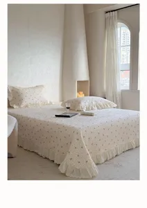 Vue de détail du couvre-lit matelassé en gaze de coton avec volants en dentelle délicate.