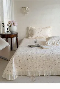 Vue détaillée d'un couvre-lit en coton matelassé avec des nœuds mignons et des volants.