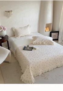 Détail exquis de couvre-lit en double gaze de coton matelassé avec bordure en dentelle et nœuds.