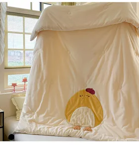 Gros plan détaillé de la couette d'hiver en velours de lait avec broderie de poussin.