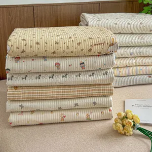 Detailed view of folded cartoon printed bed sheets and quilt covers in cozy bedroom scene.