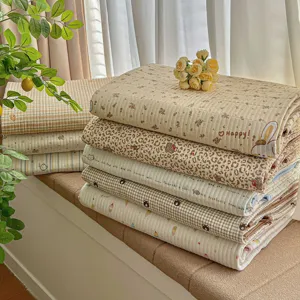 Quilted bed cover set detail showing soft fabric texture and cute cartoon floral printed patterns.