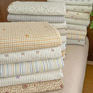 Detailed shot of soft printed quilt stack, various cute patterns, cozy bedroom decor.