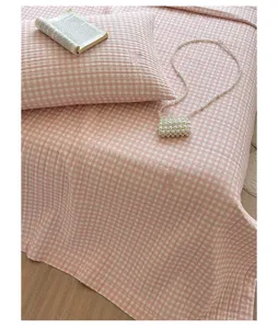 Primer plano de la bonita colcha acolchada a cuadros rosa con funda de almohada.