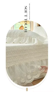 Vista detallada de colcha acolchada de terciopelo de leche grueso con elegantes volantes de encaje.