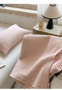 Primer plano que muestra la textura suave de la manta acolchada rosa en la habitación.