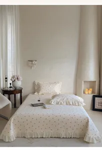 Vue detaillee du couvre-lit matelasse en coton avec imprime floral et elegant volant.