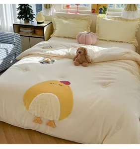 Détail de couette d'hiver en velours de lait épais avec broderie de poussin et tissu doux.