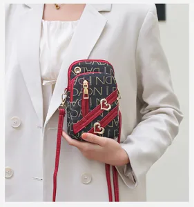 Women mini crossbody phone bag stylish vertical shoulder purse with heart decor.