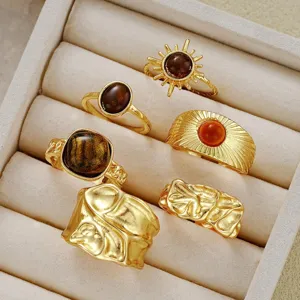 Close-up of vintage gold ring set with irregular textures and amber stones in a box