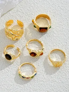 Detail view of a vintage-style gold ring set featuring irregular textures and amber stones.