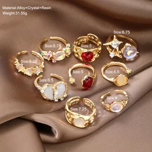 Set of 9 vintage gold adjustable enamel rings featuring crystal and resin accents