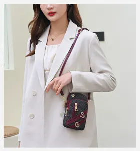 Vertical crossbody phone bag for women, mini shoulder bag with heart charms detail.