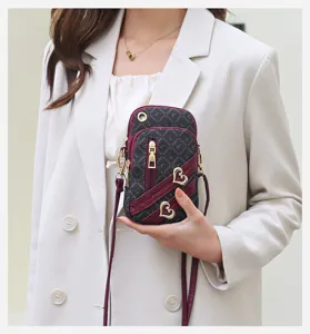 Stylish vertical mini crossbody phone bag with heart metal decor and strap for women.