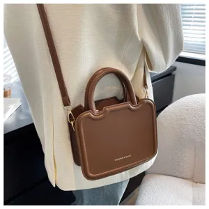 Chic brown top-handle crossbody bag for women, retro PU leather shoulder bag with structured design.