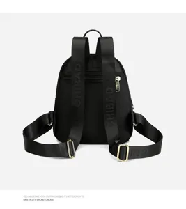Detailed view of black nylon mini backpack strap and premium metal zipper hardware.