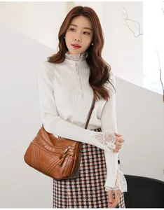 Detail view of the multi-pocket washed leather crossbody bag worn by model, soft texture.