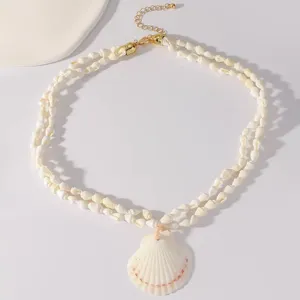 Gedetailleerde close-up van een dubbellaagse geweven schelpenketting met hanger