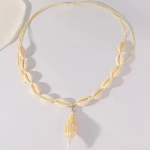Detail macro-opname van een geweven ketting met natuurlijke kauri-schelpen voor strandmode.
