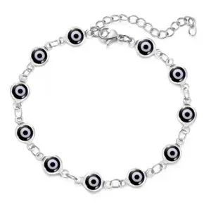 Nahaufnahme eines silbernen Armbands mit schwarz-weißen Evil-Eye-Glücksbringer-Anhängern.