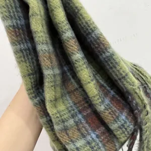 Green plaid winter scarf detail, soft textured knit fabric, cozy everyday accessory.