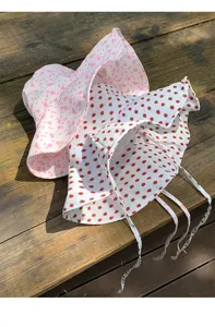 Detail view of cute strawberry and floral bucket hat, summer sun protection, double-sided design