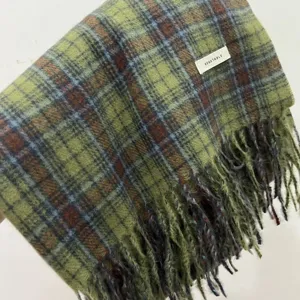 Green plaid scarf detail shot, cozy winter fringe woolen accessory for women daily wear.