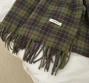 Green plaid scarf detail close-up view, cozy winter tassel wool blend fabric display