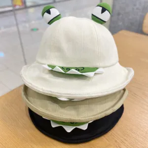 Close-up detail of cute 3D frog eyes bucket hat stack, funny cartoon design, cotton sun cap.