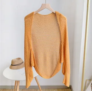 Detail view of yellow hollow-out knit cardigan, lightweight summer office shawl and shrug.