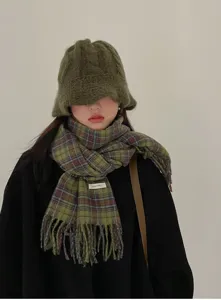 Detailed view of the winter green plaid scarf with fringe and fuzzy bucket hat outfit showcase.
