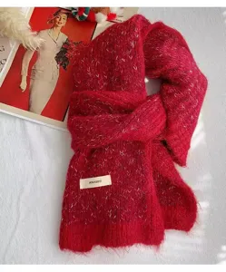 Close-up detail of a soft red fluffy knit winter scarf, cozy texture and warm accessory.