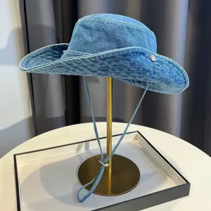 Close-up detail of the vintage washed denim bucket hat with windproof rope and metal buckle.