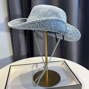 Retro washed denim bucket hat detail view with adjustable chin strap and sun protection design.