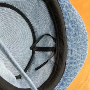 Detailed inner view of retro washed denim bucket hat, showing neat black lining and ribbon.