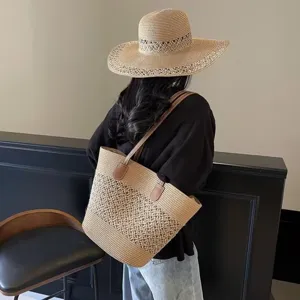 Detalle de vista trasera con el elegante sombrero de paja y bolso grande tejido.