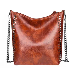 Stylish brown soft leather shoulder bag for women, featuring chic metal chain straps and rivets.