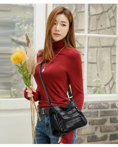 Detail shot of black washed soft leather crossbody bag with multi-zipper design for women.