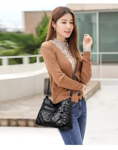 Soft leather shoulder bag detail, black quilted design with multi-pocket convenience for daily wear.