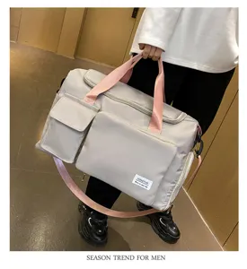 Detalles de la bolsa de viaje gris claro con múltiples bolsillos y correas rosas.