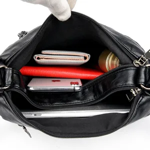 Black soft leather crossbody shoulder bag with double layer large capacity design for women.