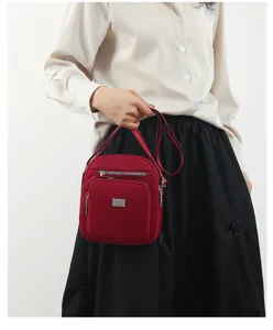 Red nylon multi-layer cross-body shoulder bag for women, lightweight travel coin phone bag.