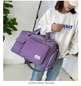 Gran bolsa de viaje morada con bolsillos dobles, correa para el hombro y diseño elegante.