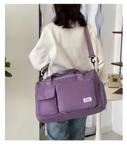 Vista detallada de la bolsa de viaje morada de gran capacidad con bolsillos y correa.