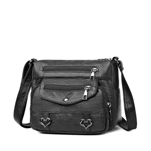 Close-up detail view of stylish black soft leather crossbody bag with multiple zipper pockets.