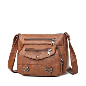 Vintage brown soft leather crossbody shoulder bag for women with multi pockets and heart decor.