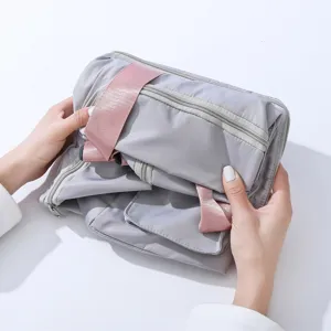 Bolsa de viaje plegable con bolsillos dobles y correas rosas para almacenamiento diario útil.