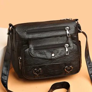 Black soft leather crossbody bag with multiple zipper pockets and heart charms for women