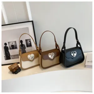 Dettaglio della borsa a tracolla stile retrò francese, chiusura a cuore chic, pelle PU.
